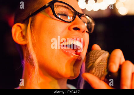 Ragazza punk cantare nel microfono, close-up Foto Stock