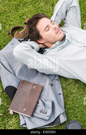 Imprenditore di dormire su erba, angolo alto Foto Stock