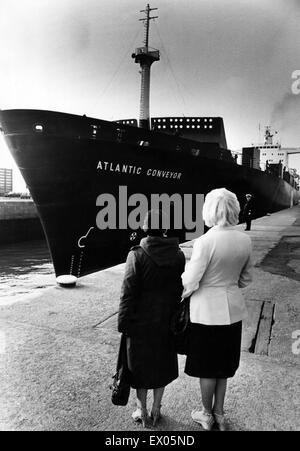 Due mogli guarda come l'atlantico trasportatore un mercante Inglese nave della marina americana, che fu requisita durante la guerra delle Falkland, lascia il Liverpool per essere rimontata e di entrare a far parte della flotta. È stata colpita il 25 maggio 1982 da due argentini aria-lanciato AM39 missili esoceto Foto Stock