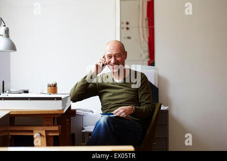 Uomo maturo al telefono in creative studio Foto Stock