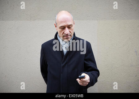 Uomo maturo utilizza lo smartphone Foto Stock