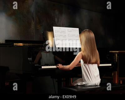 Vista posteriore di una ragazza suonare il pianoforte sul palco Foto Stock