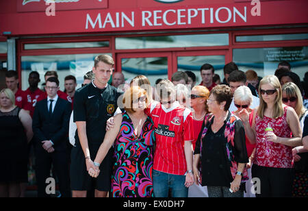 Walsall, West Midlands, Regno Unito. 03 Luglio, 2015. Il lutto figlia della madre e la sorella Suzanne Evans stand con suo figlio Owen Richards e Maureen Evans tra centinaia di persone che hanno aderito alla nazione come cadde in silenzio a mezzogiorno, una settimana dopo che 38 persone sono state ucciso da 23-anno-vecchio studente Seifeddine Rezgui presso il resort sulla spiaggia di Sousse. Tra le vittime vi sono tre membri della stessa famiglia, Walsall FC sostenitori, Joel Richards, Adrian Evans e Patrick Evans. Credito: Jane Williams/Alamy Live News Foto Stock