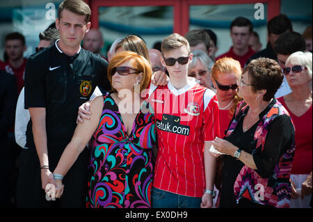 Walsall, West Midlands, Regno Unito. 03 Luglio, 2015. Il lutto figlia della madre e la sorella Suzanne Evans stand con suo figlio Owen Richards e Maureen Evans tra centinaia di persone che hanno aderito alla nazione come cadde in silenzio a mezzogiorno, una settimana dopo che 38 persone sono state ucciso da 23-anno-vecchio studente Seifeddine Rezgui presso il resort sulla spiaggia di Sousse. Tra le vittime vi sono tre membri della stessa famiglia, Walsall FC sostenitori, Joel Richards, Adrian Evans e Patrick Evans. Credito: Jane Williams/Alamy Live News Foto Stock