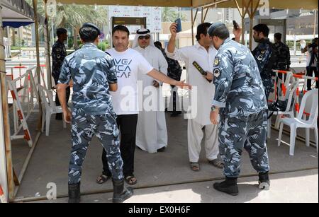 Kuwait City in Kuwait. 03 Luglio, 2015. Le guardie di sicurezza controllare i musulmani che partecipano nella comune preghiera del venerdì all'ingresso della Grande Moschea di Kuwait City, il 3 luglio 2015. Il comune di preghiera del venerdì si è tenuta a rafforzare il senso di solidarietà nazionale fra sunniti e sciiti, una settimana dopo un attacco suicida da uno Stato islamico simpatizzante di adoratori sciita. Credito: Xinhua/Alamy Live News Foto Stock