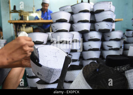 Gresik, Java Orientale, Indonesia. 3 Luglio, 2015. EAST JAVA, Indonesia - 03 luglio: i lavoratori completare la creazione del cranio cap a tenda zucchetto casa industria sulla luglio 03, 2015 a Gresik, Java Orientale Provincia, Indonesia. Tenda zucchetto sono venduti al sud-est asiatico e il Medio Oriente, Tenda zucchetto sempre utilizzato dal presidente dell Indonesia e del sultano Hassanal Bolkiah. © Sijori Immagini/ZUMA filo/Alamy Live News Foto Stock