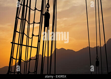 Rigging e pulegge in legno / blocchi sul bordo della Oosterschelde, tre-masted topsail schooner stagliano tramonto Foto Stock