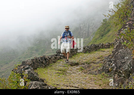 Passeggiate turistiche lungo il sentiero nella Ribeira Grande valle coperta di nebbia spessa sull'isola di Santo Antão Capo Verde Foto Stock