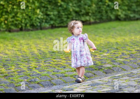 Carino piccolo bambino ragazza camminare nella città su una soleggiata serata autunnale Foto Stock