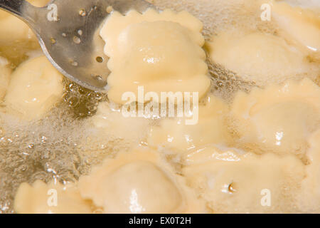 Gli gnocchi cuochi in una pentola con acqua bollente Foto Stock