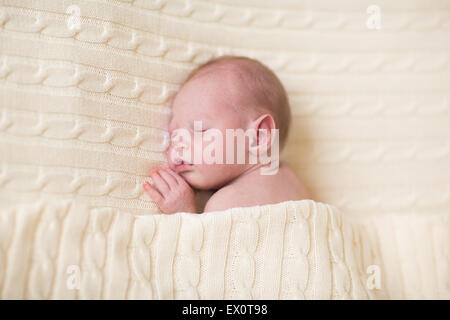 Adorabili piccolo neonato dorme sotto una calda coperta di maglia Foto Stock