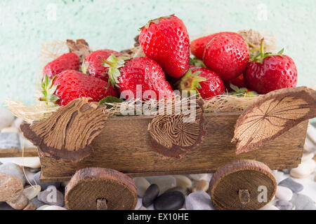 Mazzetto di fragole fresche impilati sul vecchio in miniatura carri Foto Stock