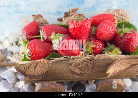 Mazzetto di fragole fresche impilati sul vecchio in miniatura carri Foto Stock