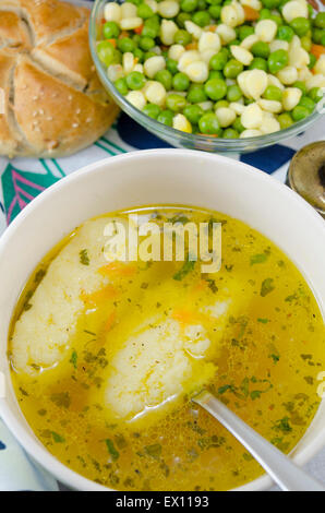 Ciotola di zuppa fatta in casa con le tagliatelle e piatto di verdure servita con pane fatto in casa Foto Stock