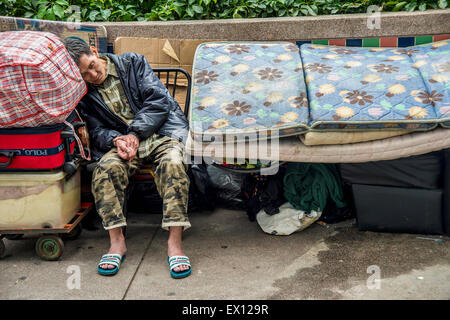 Senzatetto uomo addormentato in Hong Kong, Cina Foto Stock