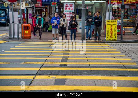 Pedoni in attesa di attraversare la strada di Hong Kong Foto Stock