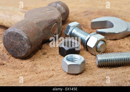 Macro shot di alcuni strumenti con i bulloni e i dadi su un tavolo di legno top Foto Stock