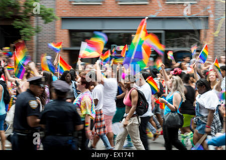 La città di NEW YORK, Stati Uniti d'America - 28 giugno 2015: celebranti all annuale Gay Pride Parade wave rainbow flag come passano la polizia. Foto Stock