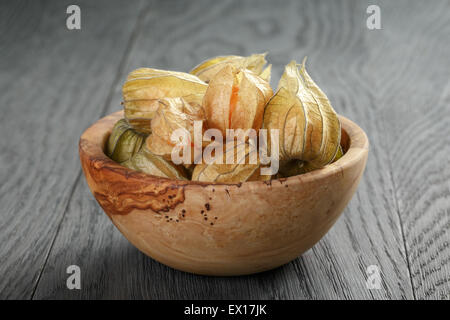 Physalis frutto nella tazza di olive su oak tavolo in legno Foto Stock