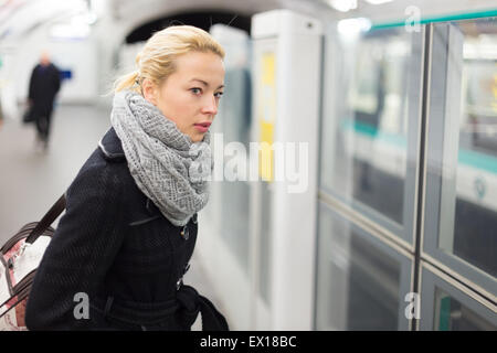 Giovane donna sulla piattaforma della stazione della metropolitana. Foto Stock