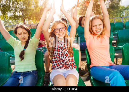 Allegro adolescenti tenere le braccia in alto durante le fasi di gioco Foto Stock