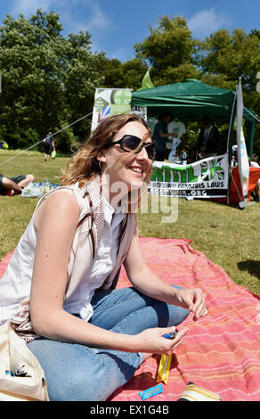 Brighton Regno Unito Sabato 4 Luglio 2015 - Una giovane donna gode dell'atmosfera rilassata al Green Pride pro cannabis caso in Preston Park Brighton oggi la manifestazione organizzata da Brighton Cannabis Club è destinato a promuovere la legalizzazione della cannabis medicinale, per celebrare la cannabis, canapa e tutte le cose verdi con molti di loro rotolamento apertamente e giunti a fumare nel parco Foto Stock