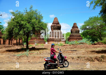 Traveler donna thai ride viaggio in moto intorno città antica di Bagan (pagano), Myanmar con oltre 2000 pagode e templi. Foto Stock