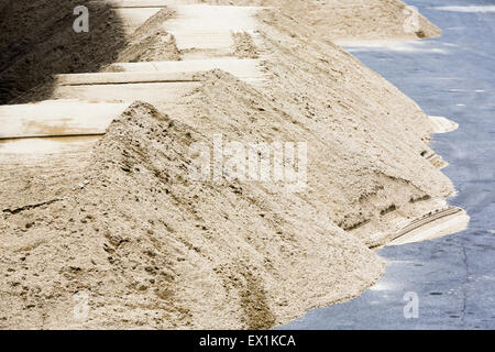 Costruzione di pali di sabbia sulla strada vicino al sito in costruzione. Foto Stock