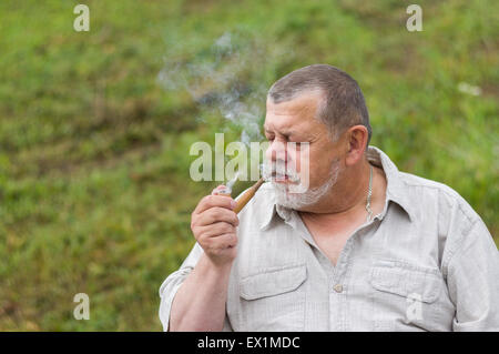 Outdoor ritratto di un uomo anziano di tabacco da fumo-pipe Foto Stock