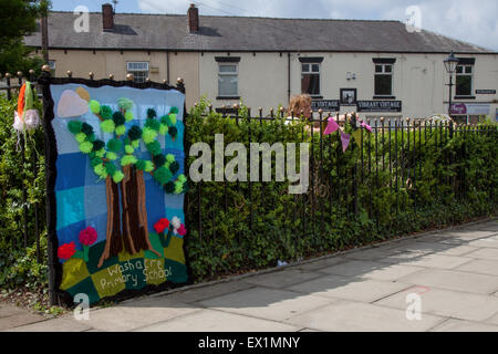 Westhoughton, Lancashire, Regno Unito 4 Luglio, 2015 Filati Festival di bombardamenti. Gruppo WCN, Rainbow mestieri, è portato a Dumfries in una festa di colori e di comunità e di intrattenimento. Da sempre giovani e vecchi, uomini e donne, esperti e il debuttante needlers coinvolto in a crochet, tessitura a maglia o a telaio piazze, lunghe strisce o rivestimenti a produrre arredamento di strada un impressionante e Curiose installazioni, il centro della città per un paio di giorni è inondato con colore. Cernan Elias/Alamy Live News Foto Stock