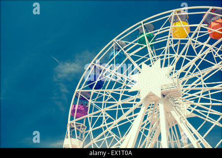 Ruota panoramica Ferris oltre il cielo blu - in stile retrò foto Foto Stock