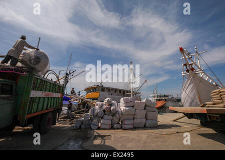 Una scena che mostra carichi, camion, navi pinisi tradizionali e lavoratori in una giornata calda al Porto di Paotere, Makassar, Sulawesi Sud, Indonesia. Foto Stock