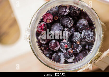 Congelati ribes nero in un vasetto di vetro closeup vista superiore Foto Stock