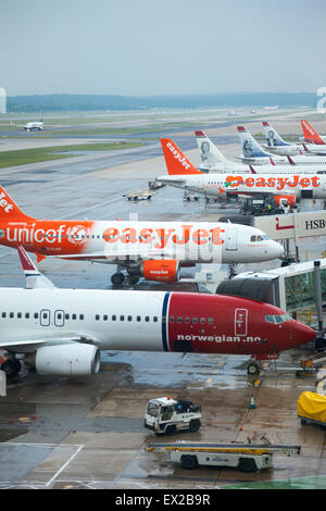 Aeroplani allineati sulla pista dell'aeroporto di Gatwick di Londra, Inghilterra Foto Stock