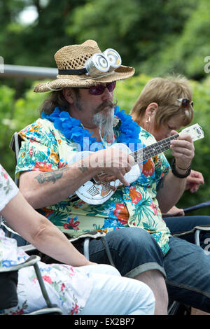 Leamington Spa Warwickshire, Inghilterra, Regno Unito. 4 luglio 2015. I fan della ukulele godere la musica in 3a Leamington Spa Ukulele Festival. Tenutasi il 4 luglio di quest anno il festival comprendeva un sapore di Americana e Hawaii. La massa busk encoraged festival va ad unirsi con canzoni tra cui quelli di Country e Western, le Isole Hawaii e Elvis Presley. La musica non-stop per tutto il pomeriggio e la sera le esibizioni da Chonkinfeckle, Red Hot Duo e Michael 'Jimmyuke' Adcock. Credito: Colin Underhill/Alamy Live News Foto Stock