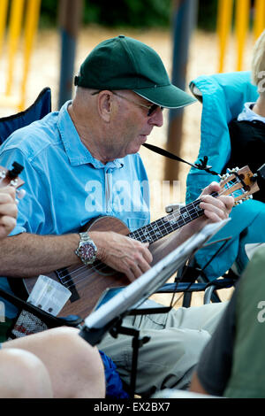 Leamington Spa Warwickshire, Inghilterra, Regno Unito. 4 luglio 2015. I fan della ukulele godere la musica in 3a Leamington Spa Ukulele Festival. Tenutasi il 4 luglio di quest anno il festival comprendeva un sapore di Americana e Hawaii. La massa busk encoraged festival va ad unirsi con canzoni tra cui quelli di Country e Western, le Isole Hawaii e Elvis Presley. La musica non-stop per tutto il pomeriggio e la sera le esibizioni da Chonkinfeckle, Red Hot Duo e Michael 'Jimmyuke' Adcock. Credito: Colin Underhill/Alamy Live News Foto Stock