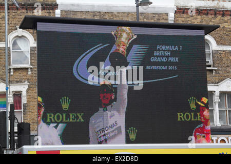 Il torneo di Wimbledon, Londra, Regno Unito. 5 Luglio, 2015. Spettatori guarda Lewis Hamilton vincere la Formula 1 Gran Premio di Gran Bretagna a Silverstone su un grande schermo in Wimbledon town center Credito: amer ghazzal/Alamy Live News Foto Stock