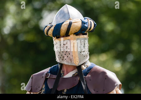 Uomo che indossa un blindato medievale la maschera per il viso e cuoio protezione della spalla. Foto Stock