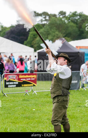 Un uomo spara un vecchio flintlock moschetto Foto Stock