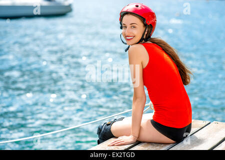 Donna in abbigliamento sportivo con rulli di pattinaggio sul molo Foto Stock