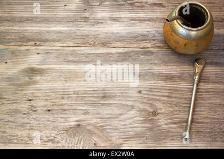 Calabash e bombilla con yerba mate su sfondo di legno. Spazio di copia a destra. Foto Stock