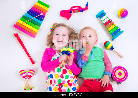 Bambino con strumenti musicali. Educazione musicale per i bambini. Colorata arte in legno giocattoli per bambini. Bambina e ragazzo riprodurre musica. Foto Stock