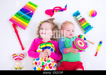 Bambino con strumenti musicali. Educazione musicale per i bambini. Colorata arte in legno giocattoli per bambini. Bambina e ragazzo riprodurre musica. Foto Stock