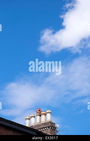 Blue Sky Whispy nuvole bianche camino spazio di copia Foto Stock