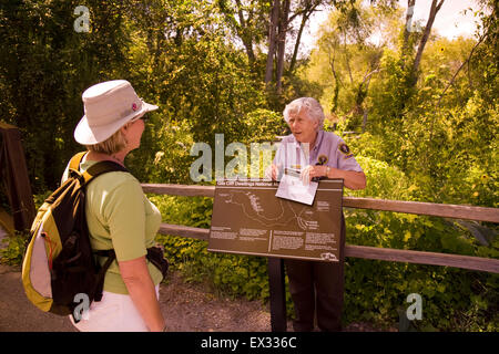 Un servizio del parco nazionale volontario mani fuori sentiero mappe e altra letteratura a Gila Cliff Dwellings National Monument. Foto Stock