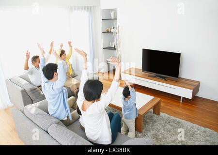 Tre generazioni di una famiglia giapponese sul divano del soggiorno Foto Stock