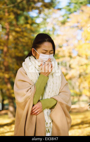 Senior donna giapponese con maschera sensazione di malessere Foto Stock