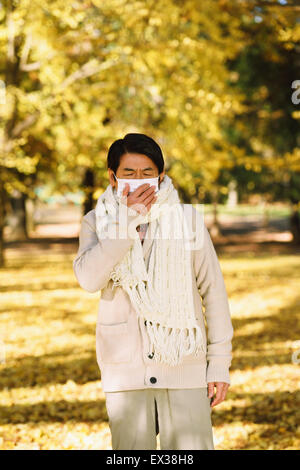 Senior uomo giapponese con maschera sensazione di malessere Foto Stock