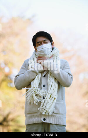 Senior uomo giapponese con maschera sensazione di malessere Foto Stock