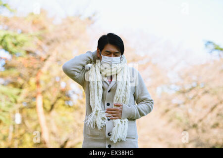 Senior uomo giapponese con maschera sensazione di malessere Foto Stock